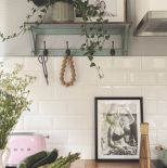 biała kuchnia z drewnianym blatem i zielonymi akcentami