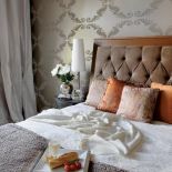 Szyku dodaje tapeta w stylu glamour oraz poduszki włoskiej marki Etro i narzuty ze sklepu Nap.