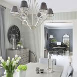 Tapeta w drobne paski, ozdobny żyrandol i świeczniki - dekoracje są dobrane idealnie.