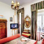 Telewizor na sztalugach wygląda jak obraz. Dzięki temu nie rzuca się w oczy w barokowej sypialni.