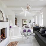 Tina kocha antyki i rękodzieło. Do białych ścian i podłóg odważnie dodaje ciemne poduchy, stare meble i chodniki.