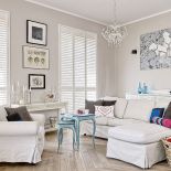 Tłem dla sztuki są białe ściany i jasne meble.