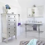 To prawdziwy salon kąpielowy z komodą, narożnikiem, pikowanym stołkiem i imponującym pomocnikiem na toaletowe drobiazgi.