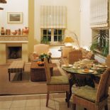 Trochę mniej oficjalny salon z kominkiem i stołem - w sam raz na śniadanie dla dwojga.