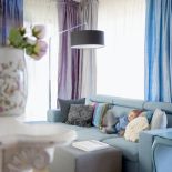 Turkusowy daje optymistyczny nastrój w jasnym, bo mocno przeszklonym salonie.