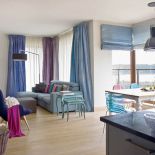 Turkusowy daje optymistyczny nastrój w jasnym, bo mocno przeszklonym salonie.