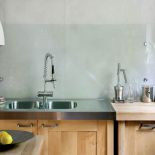 Tynki w kuchni udają beton. Dom drzewami otulony