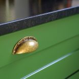 zielone szafki kuchenne z czarnym blatem