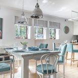 Ukochane biele (kuchenne fronty) i błękity (krzesła thonety i hokery w jadalni).