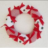 Uszyty z tkanin bawełnianych w tonacji biało-czerwonej, ozdobiony czerwonymi, nieobrębionymi kokardkami i guzikami.