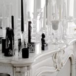 W białym pokoju odbite w lustrze kryształowe świeczniki wyglądają naprawdę magicznie. Nieliczne czarne akcenty potęgują