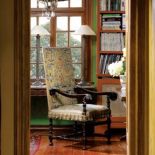 W bibliotece stoi stary fotel z oryginalną haftowaną tapicerką i pasmanterią.