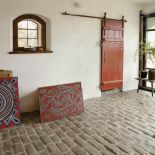 W bramie na kamiennej posadzce Anna urządziła swój warsztat pracy – układa barwne mozaiki.