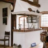 W całym domu znajdziemy beton, surowe cegły, bielone ściany, drewniane belki. O takie wnętrze nie