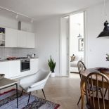 W całym mieszkaniu dominuje biały kolor, który gdzieniegdzie przełamują drewniane meble i kolorowe etniczne dywany.