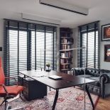 W gabinecie stoi lekkie biurko, kolorowe krzesło oraz minimalistyczne lampy biurkowe.