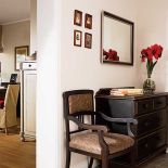 W holu stoi ciemna komoda. Dyskretny urok czerwieni