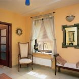 W holu stoi fotel i bankietka. Miejsce dla drobiazgów