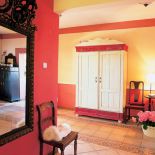 W holu stoi szafa zdobiona motywami kwiatowymi.