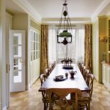 W jadalni duży drewniany stół. Apartament w kamienicy na Powiślu