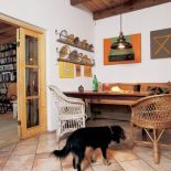 W jadalni stoi drewniana ława i wiklinowe fotele.