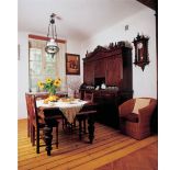 W jadalni stoi kredens, stół i krzesła.