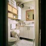 W jasnej łazience uwagę zwracają drewniane akcenty.