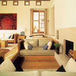 W jasnym salonie akcentem jest obraz namalowany odcieniami czerwieni.