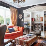 W klasycznym gabinecie z pikowanymi fotelami i kanapą znalazło sie miejsce na zabawny akcent - stolik w panterkę.