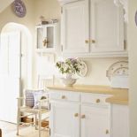 W kuchni Liz wyrzuciła część ponurych brązowych szafek po poprzednich właścicielach, a resztę przemalowała na kremowo.