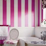 W łazience tapeta w biało różowe pasy.