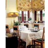 W oknach wiszą rolety w kieciste motywy.