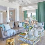 W oknach zasłony uszyte z jednolitego materiału w odcieniu miętowej zieleni.