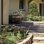 W okół domu otoczone kamieniem rabaty.