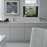 W otwartej na salon kuchni warunki dyktuje biel obecna na frontach kuchennych, krzesłach, stole jadalnianym