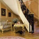 W owalnym holu zachwycają schody z włoskiego, czerwonego trawertynu, z kutą balustradą, oraz bogate sztukaterie.