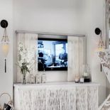 W salonie biały ekran z rafii, za którym ukrywa się telewizor.