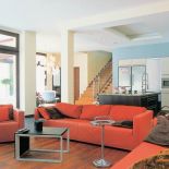 W salonie czerwone kanapy. Modernistyczna willa w stolicy