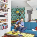 W salonie dwie kolorowe kanapy, vis-a-vis: niebieska i pomarańczowa.