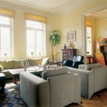 W salonie kanapa i fotele. Mieszkanie w stuletniej kamienicy