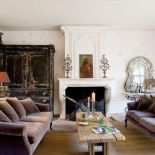 W salonie kanapy, stolik i stary kredens.