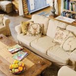 W salonie obok drewnianego stolika kanapa i fotele.