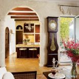 W salonie zdobiony drewniany zegar. Rezydencja w mieszkaniu