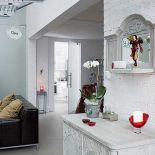 W salonie znajdziemy jasne meble ozdobione roślinnymi ornamentami.