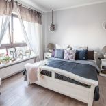 W sypialni królują pastelowe granaty, ocieplone szarobrązowymi dodatkami.