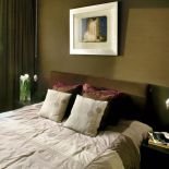 W sypialni łóżko ozdobione poduszkami.