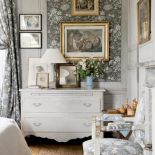 W sypialni motywem przewodnim jest szara tkanina z kwiecistym wzorem.