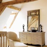 W sypialni na poddaszu obowiązuje spokojny styl. Najważniejsze są belki podtrzymujące dach. To do nich