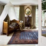 W sypialni nad stylowym łóżkiem zawieszono zwiewny baldachim.