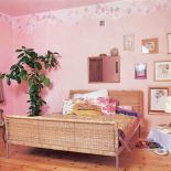 W sypialni stoi duże wiklinowe łóżko.